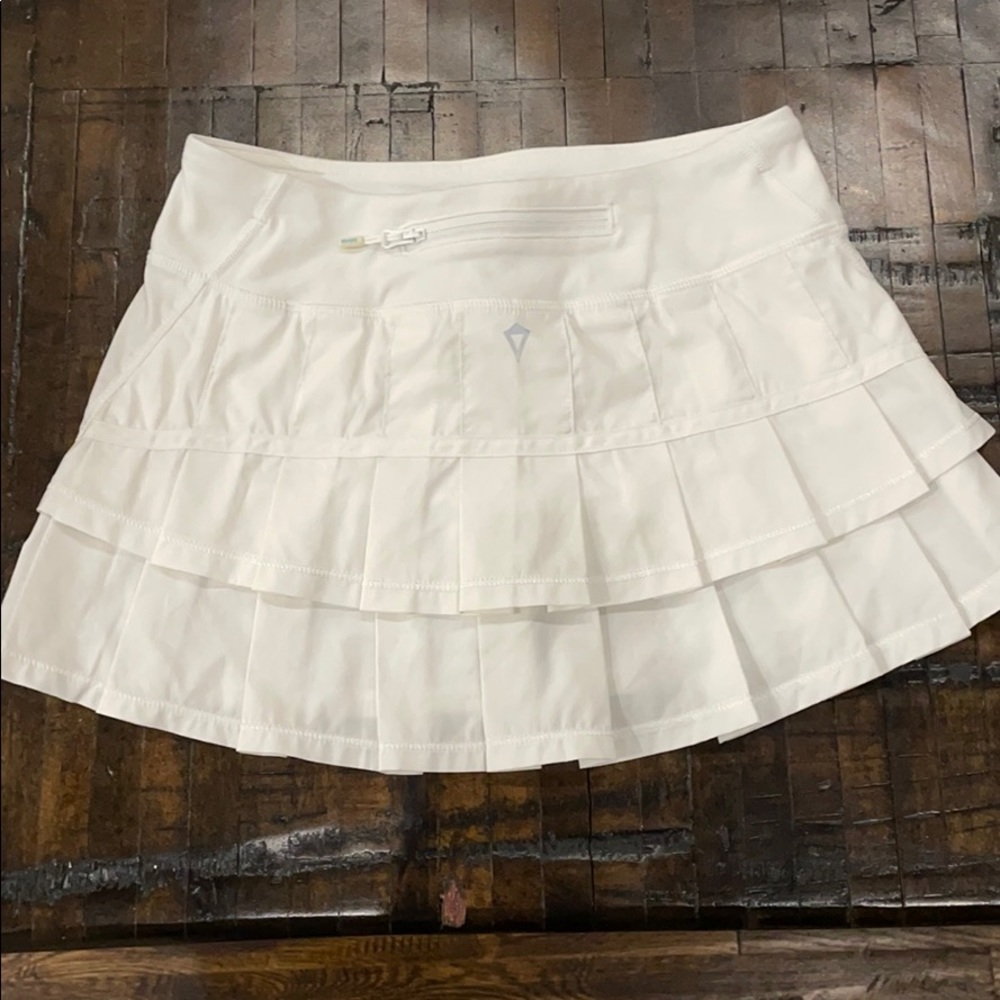 Girl white Ivivva tennis skirt.